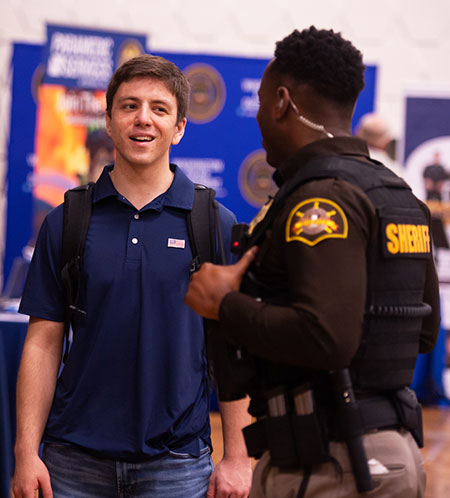 student and police officer at career fair