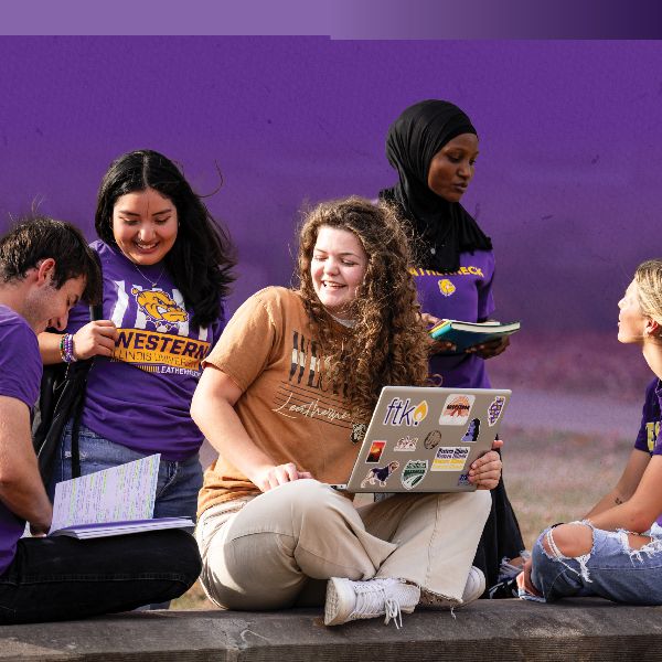 group of students sitting outside talking