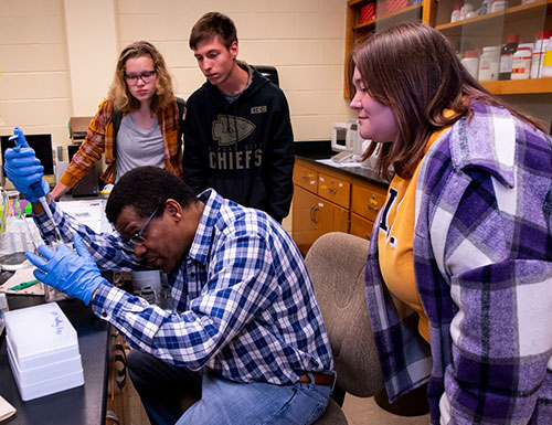 students and faculty in a lab