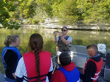 students in a boat learning about fish