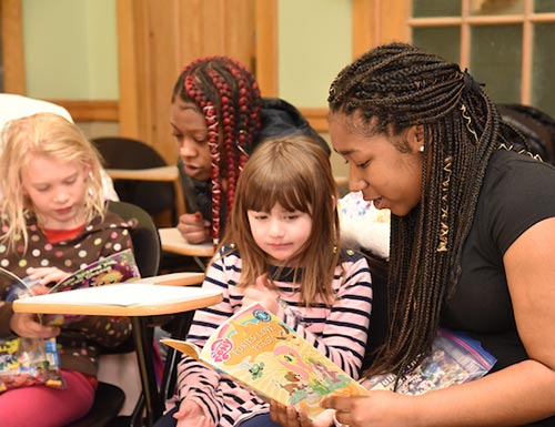 students reading to grade school kids