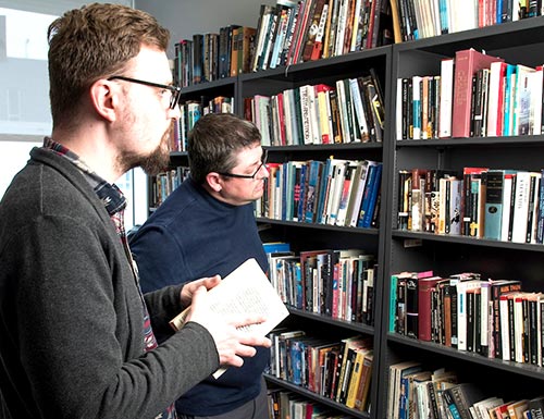 faculty and student looking at books