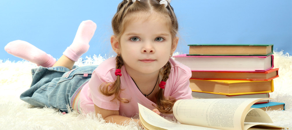girl reading from stack of books
